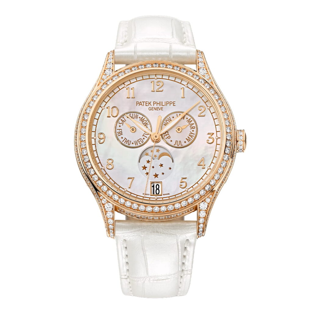 Eine luxuriöse Patek Philippe Komplizierte Uhren Armbanduhr mit weißem Lederarmband, Roségoldgehäuse, Diamantlünette, Perlmuttzifferblatt, goldenen Ziffern und drei Unterzifferblättern, die Tag, Datum und Mondphase anzeigen.